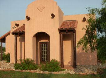 A tan building with a brown roof and windows.